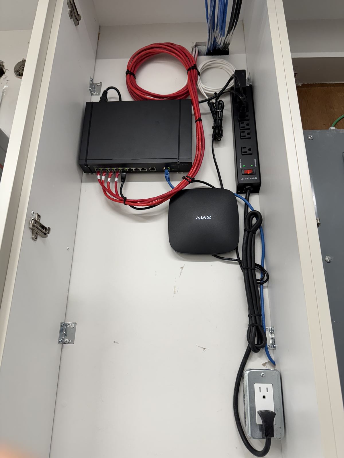 Ajax alarm hub and PoE switch neatly installed in a structured wiring panel