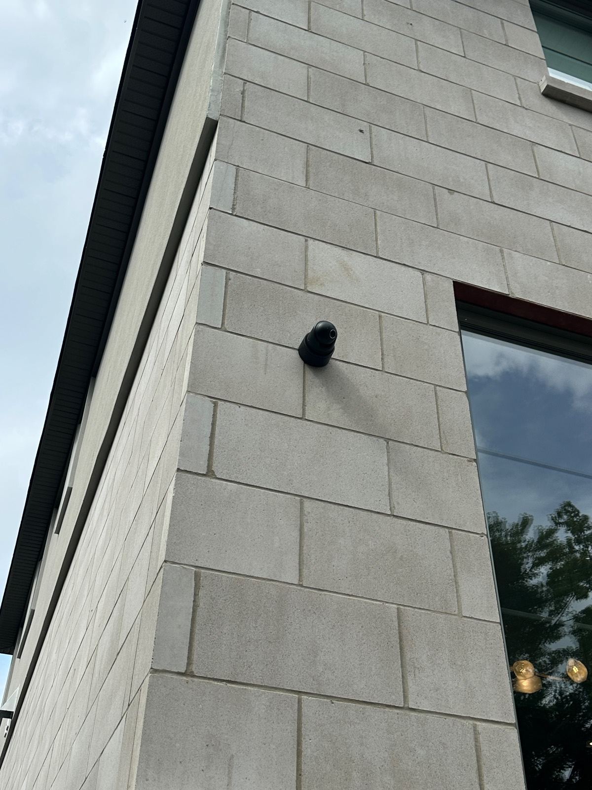 Turret camera mounted on the stone corner of a custom home