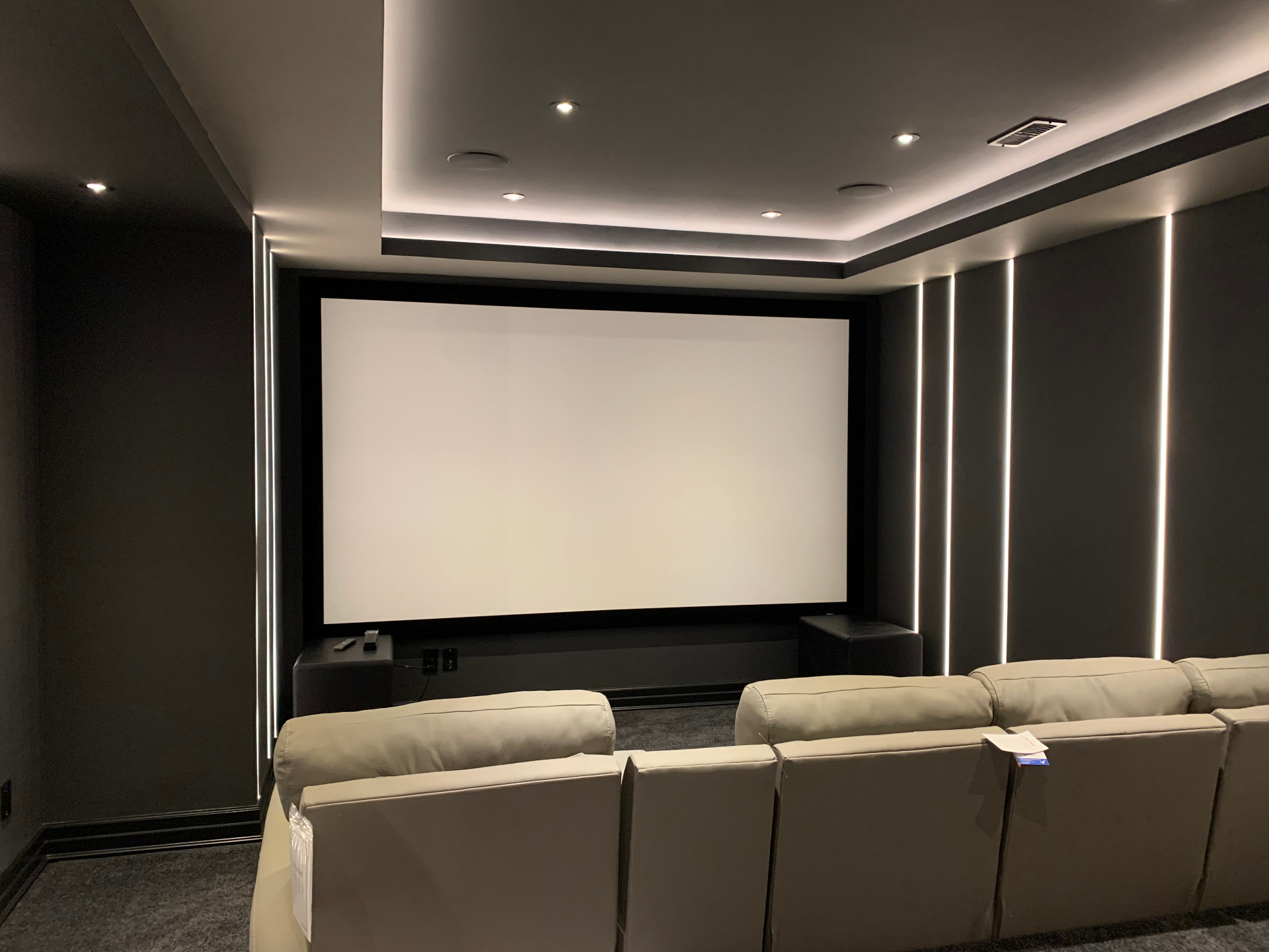 Front row seating facing the custom cinema screen with LED accent lighting