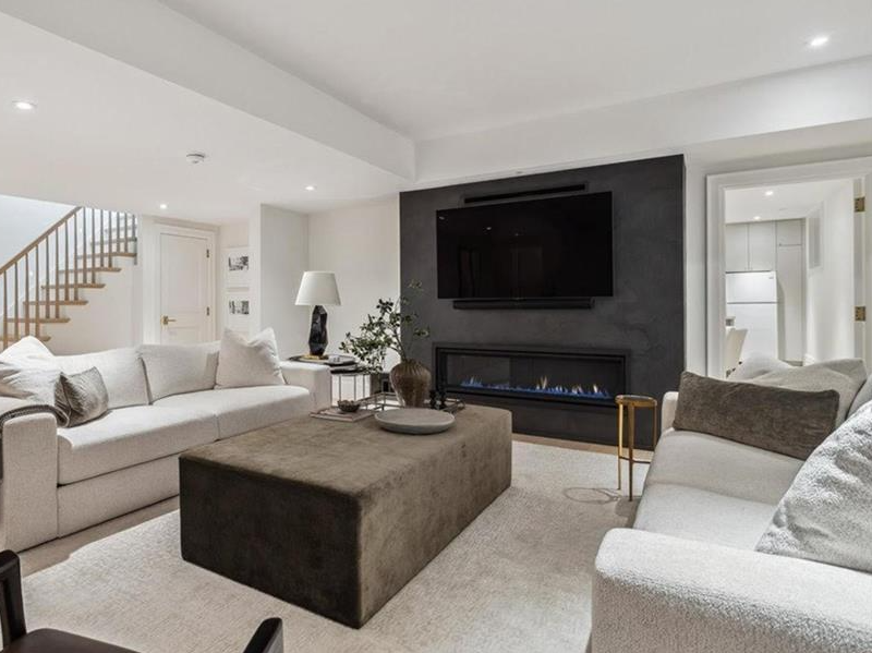Basement lounge with fireplace feature wall and wall-mounted television