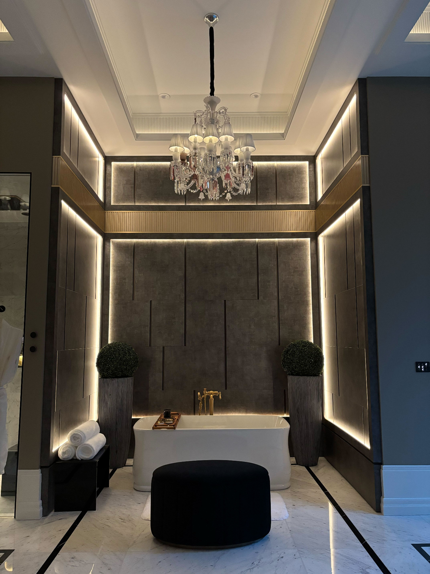 Luxury bathroom with layered architectural lighting and statement chandelier