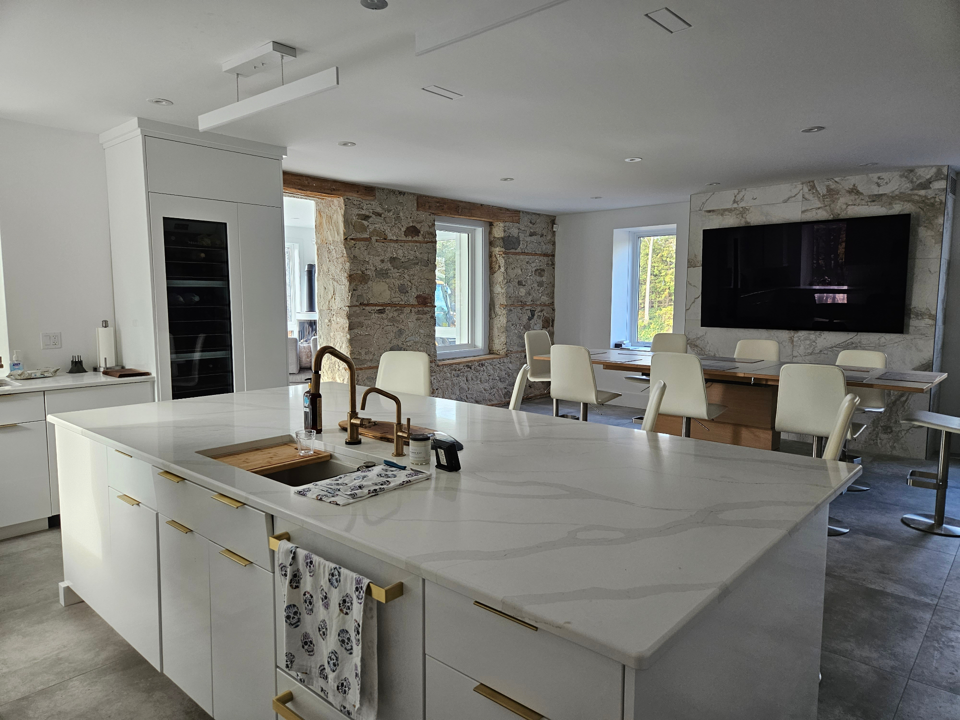 Modern kitchen with large-format TV integrated into marble feature wall