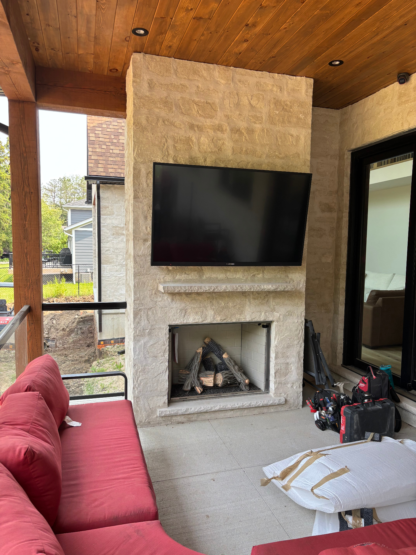 Outdoor TV installation above fireplace